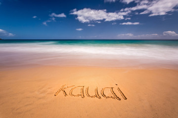 The word Kauai written on the sand of a beach in Kauai, Hawaii