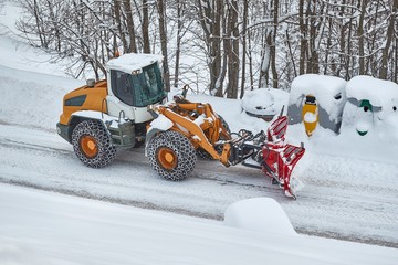 Snowplow machine clearing snow from roads after heavy snowfall in the Alps