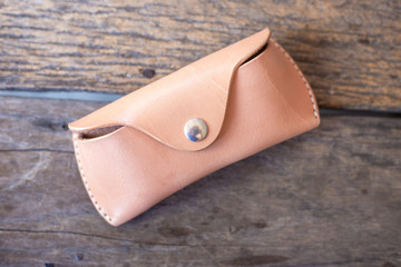 Genuine leather glasses case handmade on wood background