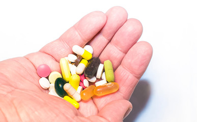 Colored pills, medicines and ampoules close-up on the palm on the hand,  background