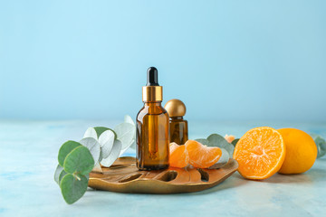 Bottles of tangerine essential oil on table - obrazy, fototapety, plakaty