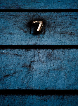 Number 7, seven, in dark subdued vintage blue background, offset with text space below.