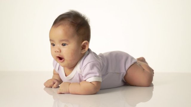 baby laying on her belly. tummy time cute baby in studio portrait