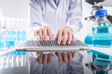 Researchers are analyzing data using a laptop. In the laboratory