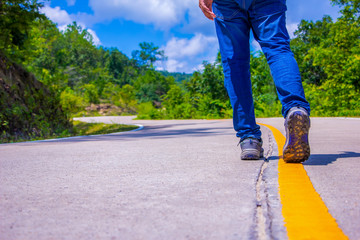 Pathway to success concept a man walk on concrete road in the forest go to the light at the destination with space area for write some text on background meaning walk to success concept