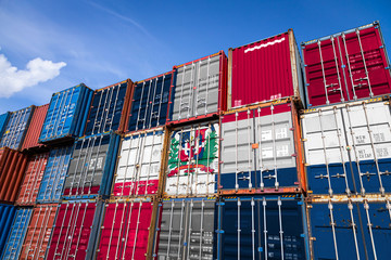 The national flag of Dominicane on a large number of metal containers for storing goods stacked in...