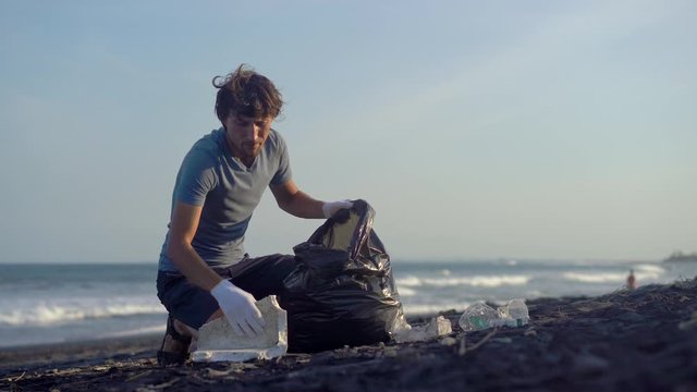 Young man clean up the beach from a trash