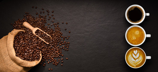 Variété de tasses de café et de grains de café dans un sac de jute sur fond noir.