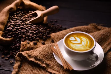 Crédence en verre imprimé Café Tasse de café au lait et grains de café dans un sac de jute sur fond de bois ancien