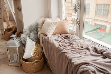 cozy place to relax by the window in the style of boho, fluffy plaid and pillows in pastel colors