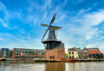Fototapeta na wymiar A windmill along the canals in Haarlem, Netherlands on a clear day.
