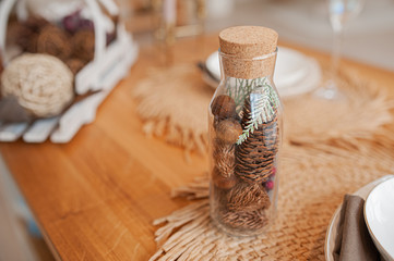 eco decoration with your own hands, a glass bottle with a cork filled with cones and natural wooden elements
