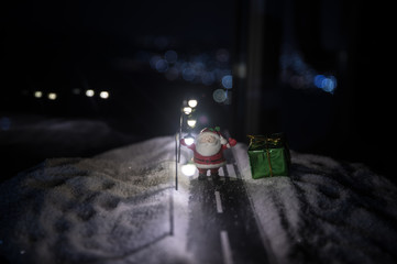 New Year miniature house in the snow at night with fir tree. Holiday concept. Selective focus