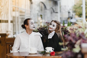 Mimes in front of Paris cafe acting like drinking tea or coffee.