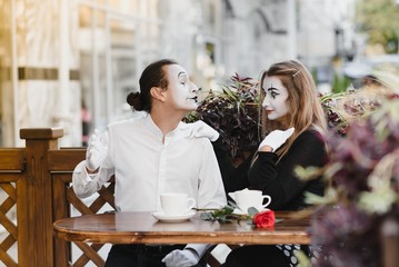 Mimes in front of Paris cafe acting like drinking tea or coffee.