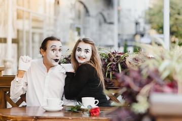 Mimes in front of Paris cafe acting like drinking tea or coffee.