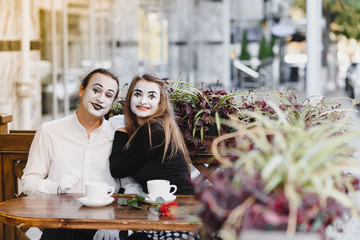Mimes in front of Paris cafe acting like drinking tea or coffee.