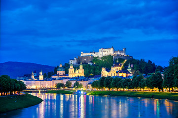 Fototapeta na wymiar A view of Salzburg, Austria along the Salzach River at night.