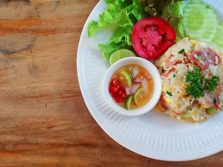 Fried rice bacon with vegetables and fried eggs white dish on wooden backgrounds above