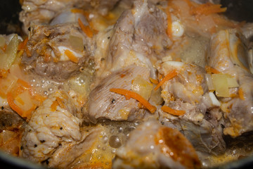 Obraz na płótnie Canvas Pork ribs marinated with spices Stewed in a pan with onions and carrots. Home cooking. Close up