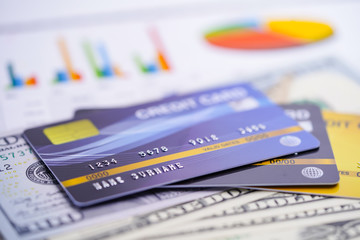 Credit card model on US dollar banknotes on graph paper.
