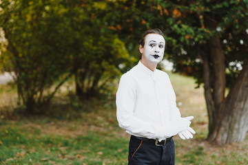 Portrait of a man, artist,clown, MIME. Shows something. Mime actor shows different emotions.