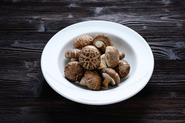 Shiitake mushrooms on the wooden background.