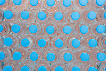 Plastic water bottle background, blue bottle caps, orderly arrangement.
