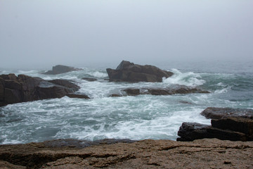 Fototapeta na wymiar Rough Seas with Waves and Rocks Surrounded by Mist