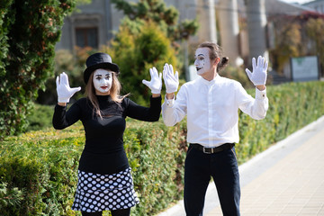 A couple of merry mimes. He hurries on a date.