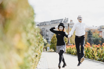 A couple of merry mimes. He hurries on a date.