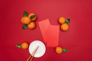 Naklejka na ściany i meble Flat lay Chinese lunar new year traditional ornage with red envelope on table top