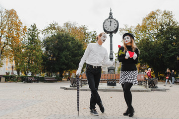 A couple of merry mimes. He hurries on a date.