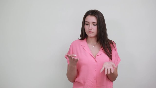 Caucasian young woman in pink shirt isolated on white background in studio showing nine fingers at camera. People sincere emotions, lifestyle concept.