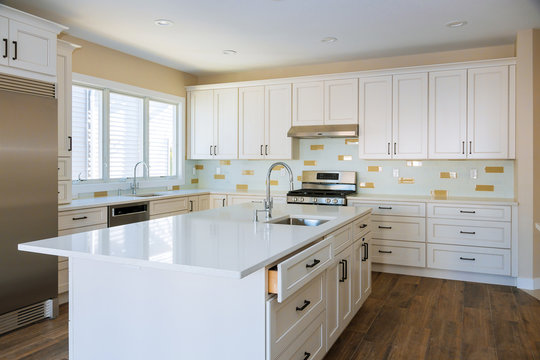 Installing cabinets and counter top a white kitchen partially installed furniture.