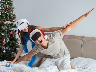 Obraz premium Happy couple celebrating christmas holiday in bed