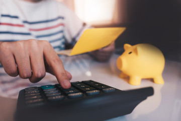 Business hands holding saving account passbook with calculator, account and saving concept.