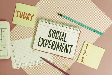 Text sign showing Social Experiment. Business photo showcasing the research project conducted with huanalysis subjects Writing equipments and computer stuffs placed above colored plain table