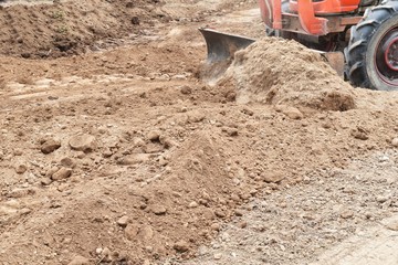 tractor push clot soil after pour from truck