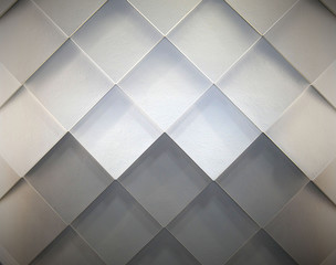 Gray and white tiles arranged on the wall in diagonal rectangular pattern.