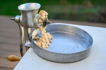 Manual clam grinder set up and starting to grind fresh caught razor clams, catch pan and table outside
