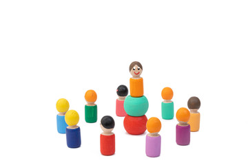 Wooden toys stand and wait for commands from their male leader. The image of building a team in front of the leader. The concept of subordinating a man to the president.