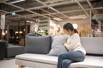Beautiful women are buying furniture into the house.
