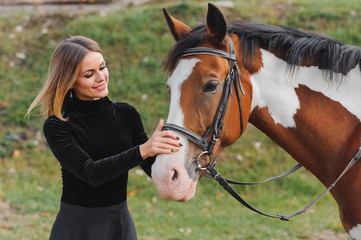 Fashionable portrait of a beautiful young woman and horse