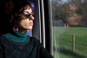 Obraz na płótnie Canvas Girl traveling in train with reflection on wiindow