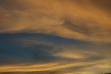 Blue sky hole that surrounding by glowing orange cloud in an evening