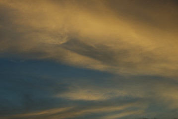 Blue sky hole that surrounding by glowing gold cloud in an evening