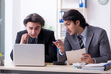 Two young employees working in the office