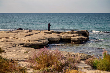 Рыбак с удочкой на берегу Каспия