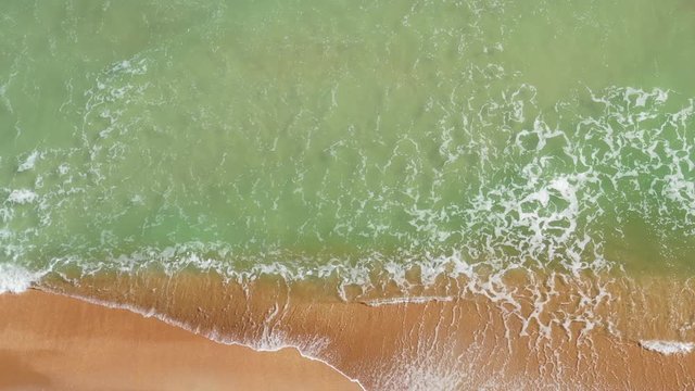 Aerial 4k footage of small waves crashing in Miami Beach